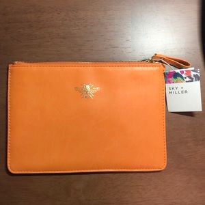 Orange zipper pouch with golden bee emblem